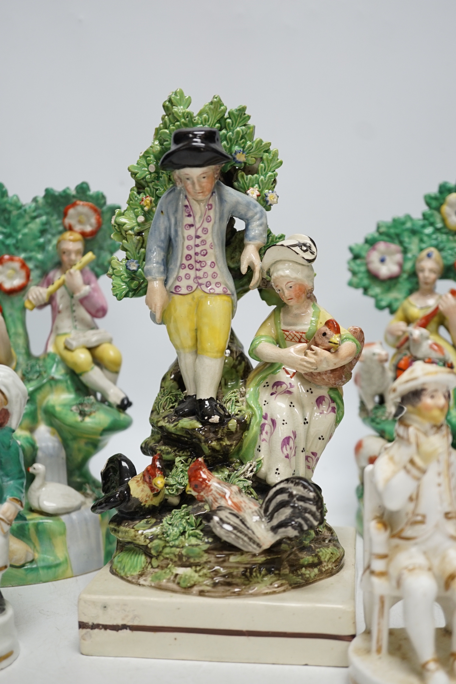 A Staffordshire pottery group of two figures with chickens, c.1800-10, a pair of early 20th century Staffordshire pottery figure groups and three small character figures, tallest 25cm high (6)